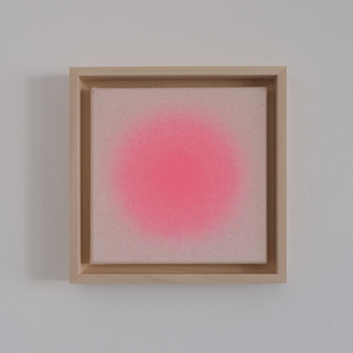 Quadratisches Kunstwerk der ZEIT-Sonderedition Sorbet »Pink« mit dezentem, neonpinkem Farbverlauf auf hellem Hintergrund, gerahmt in naturfarbenem Holzrahmen, an einer weißen Wand hängend.