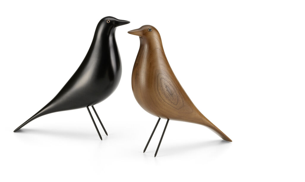 Zwei dekorative Vogel-Statuen, ein schwarzer und ein brauner Vogel, im minimalistischen Design von Eames, stehend auf dünnen, metallischen Beinen vor einem weißen Hintergrund.