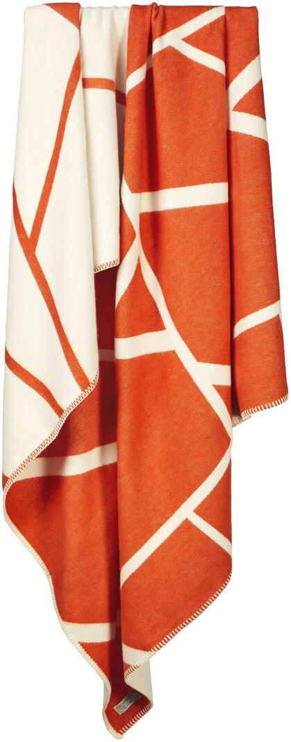 Baumwolldecke »Twig« in Zimtrot mit geometrischem Muster, drapiert über eine Stange. Eine stilvolle und wärmende Ergänzung für jedes Zuhause.