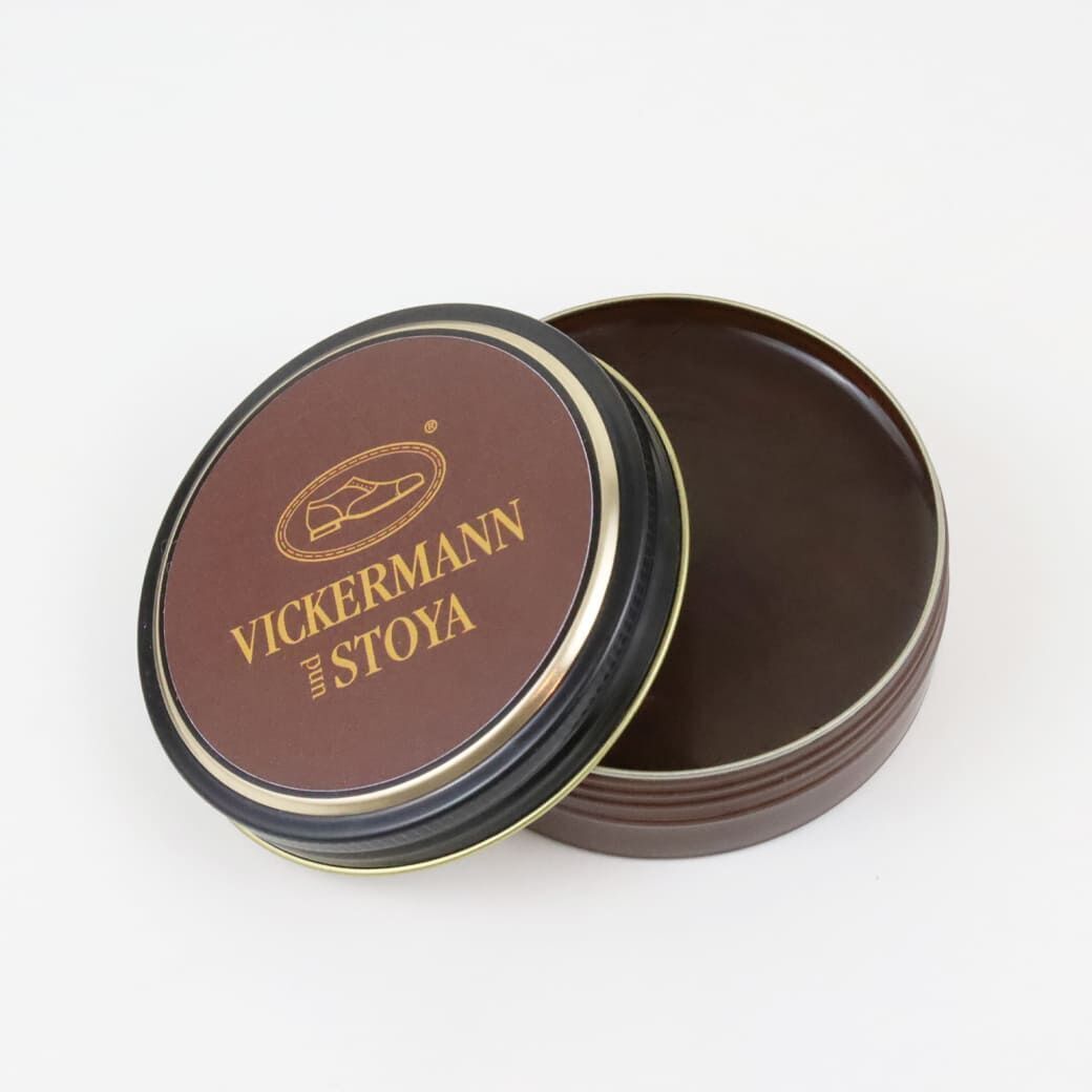 Ein rundes Lederpflege-Set von Vickermann und Stoya. Das Set besteht aus einer braunen Dose, die teilweise geöffnet ist und braune Schuhcreme zeigt.