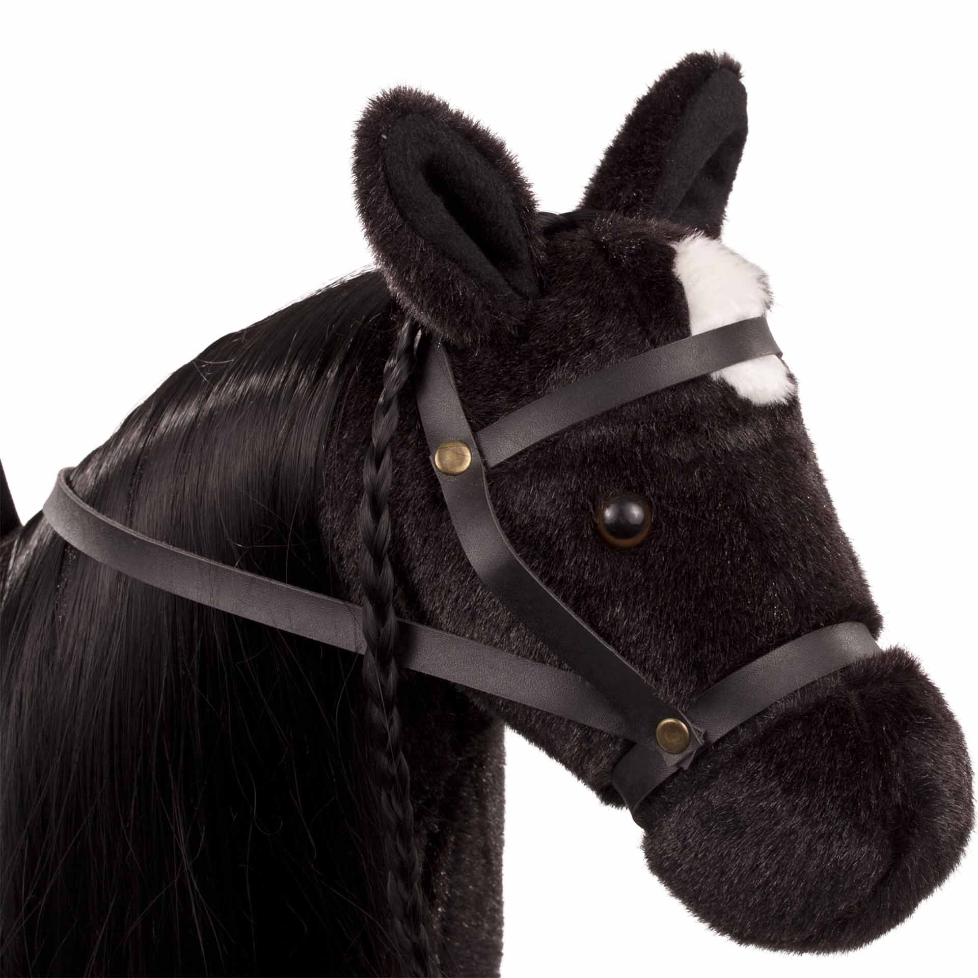 Nahaufnahme eines schwarzen Steckenpferds mit weißer Blesse, weicher Plüschoberfläche, schwarzen Knopfaugen und Lederriemen als Zaumzeug. Geeignet als Spielzeug für Kinder.