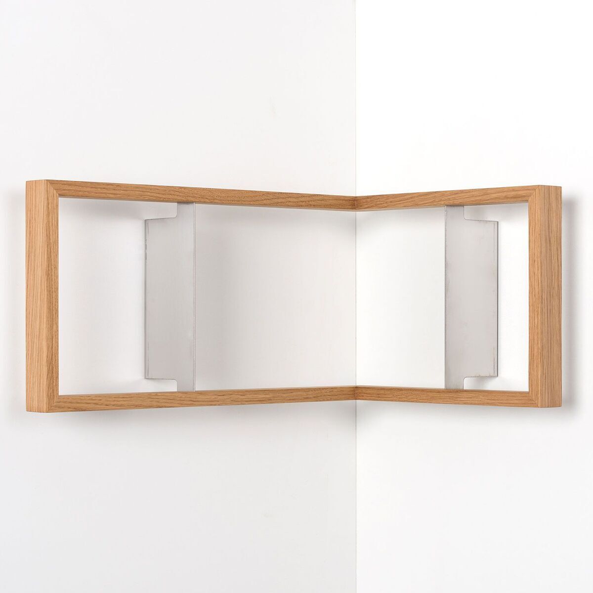 Eckregal „b-eck“ aus Holz und Metall in einer minimalistischen, modernen Gestaltung. Das Regal hat eine schlichte braune Holzoberfläche und wird mit weißen Metallwinkeln an der Wand befestigt. Geeignet für die Wandmontage in Ecken, ideal für Bücher oder Dekorationsobjekte.