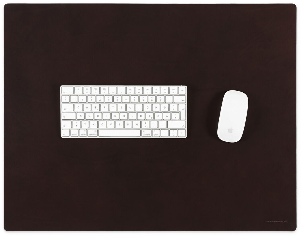 Eine braune Schreibtischunterlage aus Leder mit einer weißen Tastatur und Maus darauf. Die Unterlage ist rechteckig und bietet eleganten Schutz und Stil für den Arbeitsplatz.