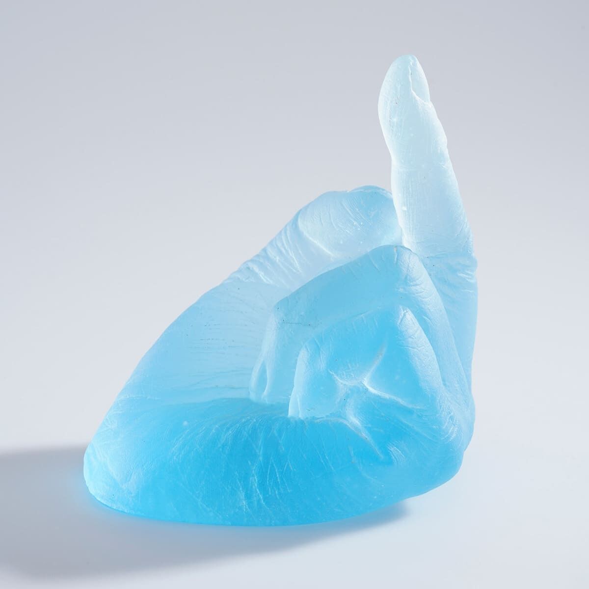 Eine halbtransparente, blaue Skulptur von Ai Weiwei, die eine Hand mit ausgestrecktem Mittelfinger darstellt.