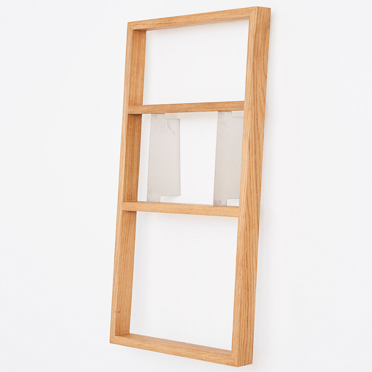 Ein minimalistisches, hölzernes Wandregal in rechteckiger Form, mit mehreren Regalböden, montiert an einer weißen Wand.