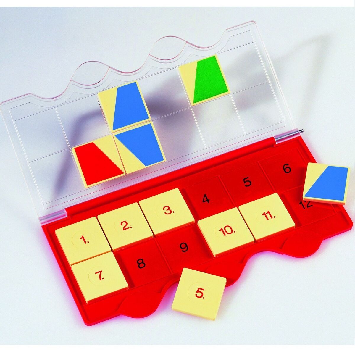 Das Bild zeigt ein pädagogisches Lernspiel namens Mini-LÜK-Set "Ich komme in die Schule". Es besteht aus einem roten, nummerierten Basisteil und neun gelben Puzzleteilen, die farbige Formenmuster in Rot, Blau und Grün zeigen.