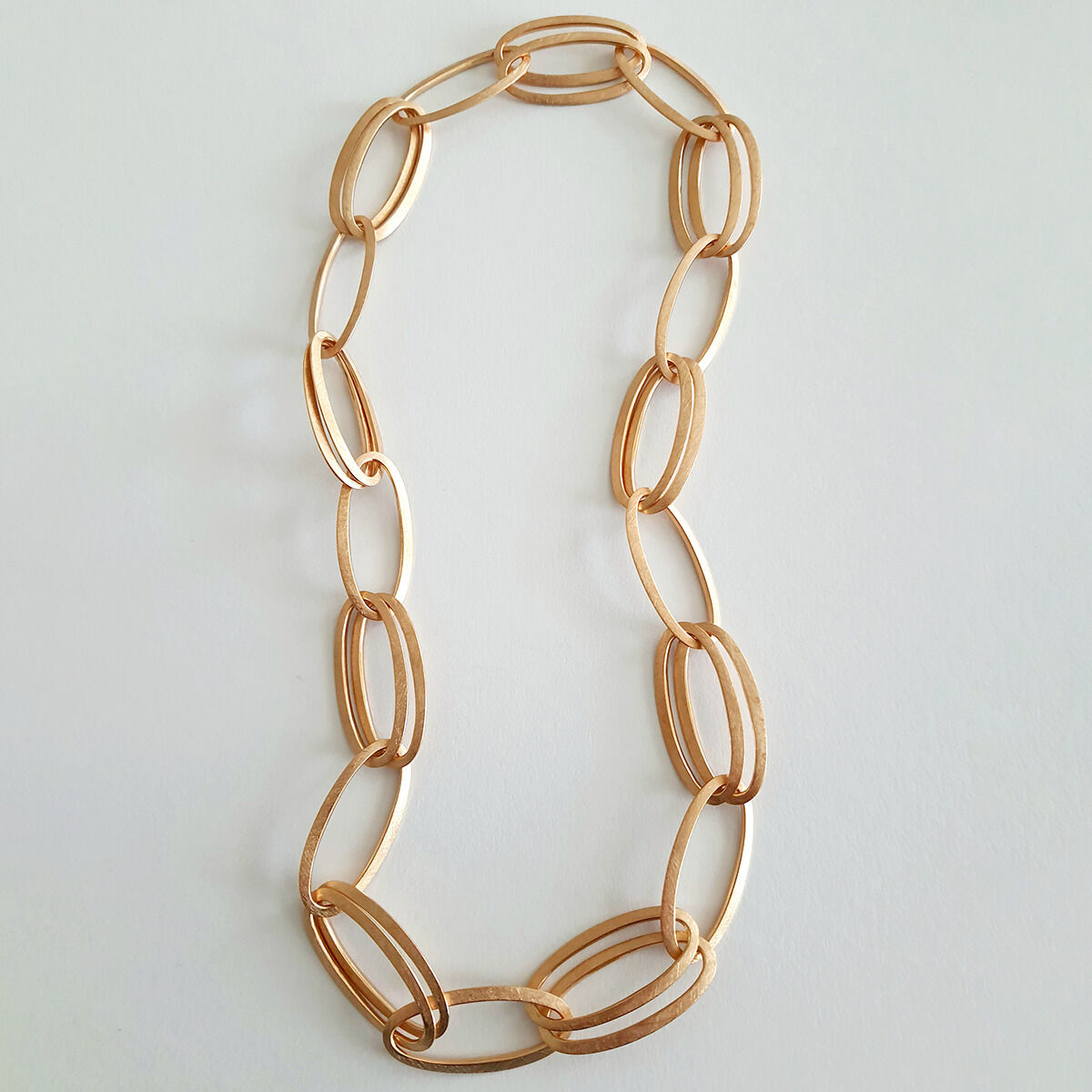 Roségoldplattierte Halskette »GRACE« von HML Berlin, bestehend aus großen, ovalen, matt schimmernden Gliedern aus 925er Silber. Das Collier liegt auf hellem Hintergrund und wirkt elegant, exklusiv und edel.