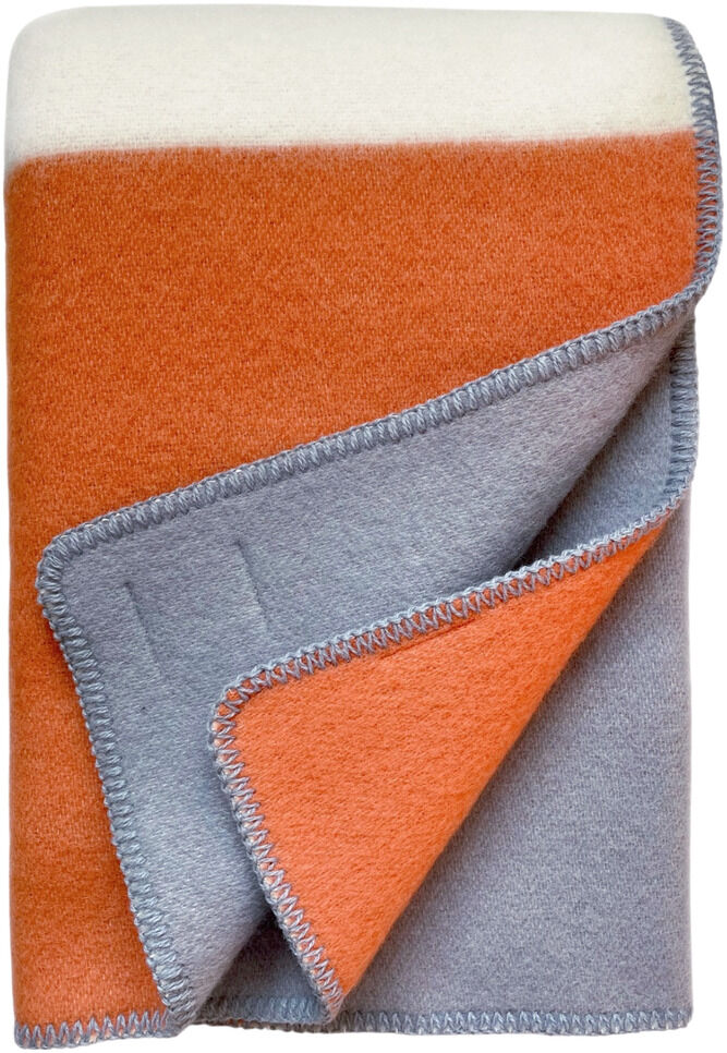 Eine Decke in Blockfarben, bestehend aus Orange, Grau und Weiß, mit einem kontrastierenden Saum, gefaltet und schichtenweise sichtbar.