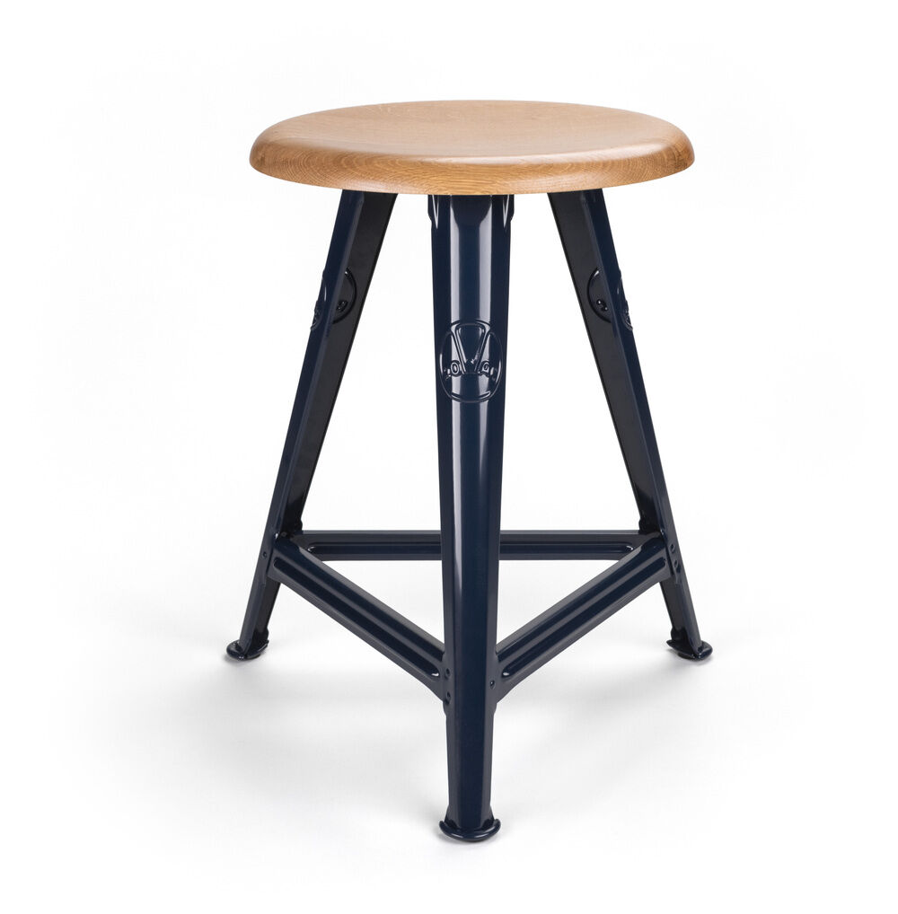 Ein moderner Hocker mit einer runden Sitzfläche aus Naturholz und einem stabilen dreibeinigen Gestell aus blauem Metall. Der Hocker vereint Industriedesign mit zeitlosem Stil und ist für verschiedene Wohnräume geeignet.