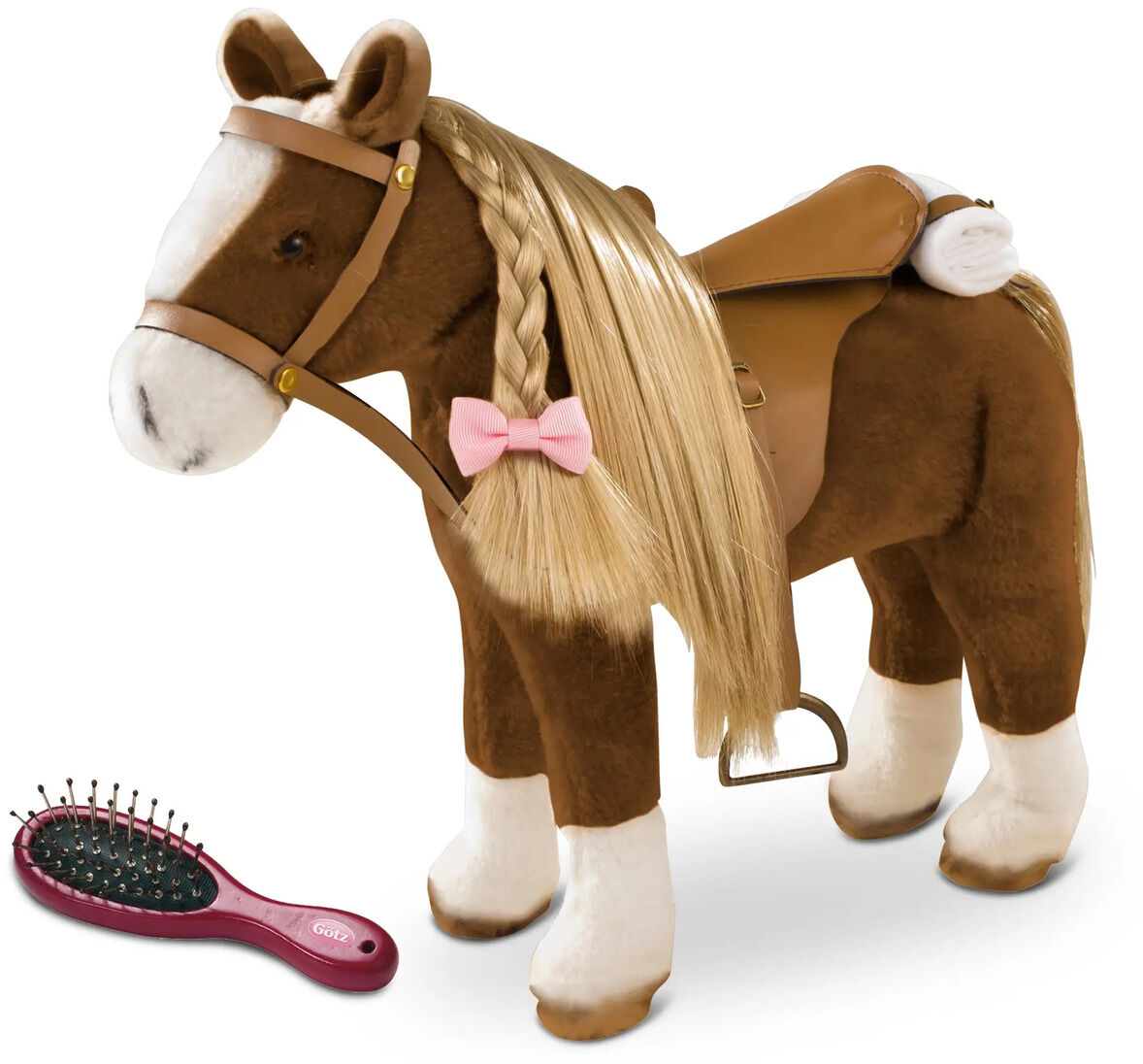 Das Bild zeigt ein braunes Plüschpferd mit beigen Details, einer geflochtenen blonden Mähne und rosa Schleife. Auf dem Rücken trägt es einen braunen Sattel. Links daneben liegt eine dunkelrote Bürste. Das Spielzeug ist für Kinder geeignet, besonders für Pferdefans.