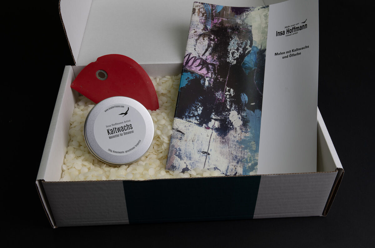 Bild eines Kunstkurs-Sets der ZEIT-Sonderedition mit Insa Hoffmann, bestehend aus Kaltwachs, Ölfarbe und einer rotfarbenen Spachtel, in einer offenen weißen Box auf schwarzem Hintergrund.