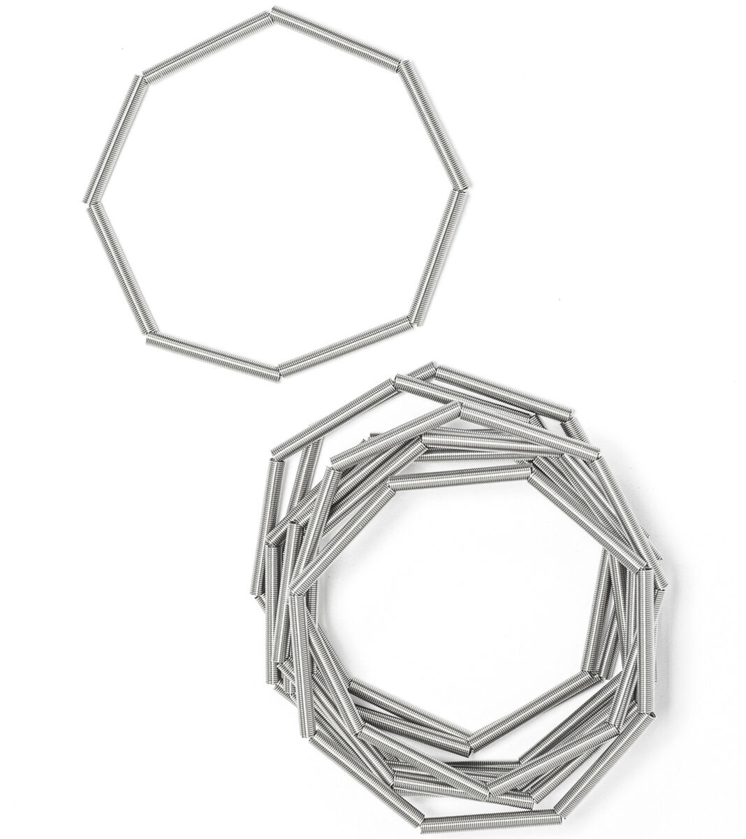 Zwei silberfarbene Edelstahlarmbänder von la molla liegen auf weißem Hintergrund, das obere einzeln als gleichmäßiges Achteck, das untere in mehreren Lagen übereinander gelegt, moderner minimalistischer Schmuck, Produkt: Armband 'MISTY'.