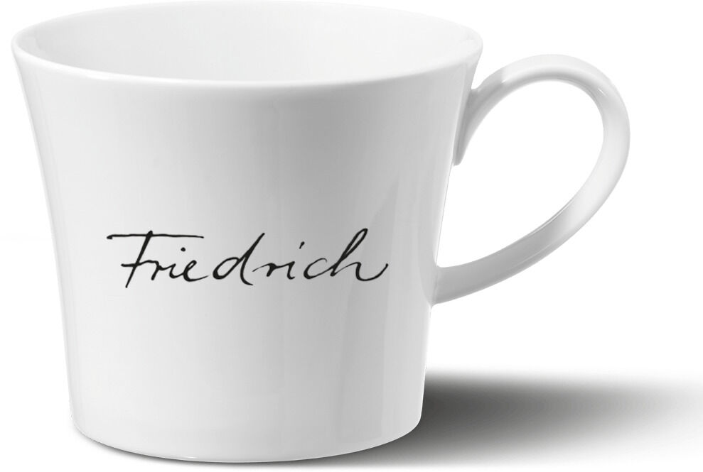 Weiße Bürotasse mit dem Namenszug ‚Friedrich‘ in schwarzer Schrift, formschön mit Henkel, auf neutralem Hintergrund.