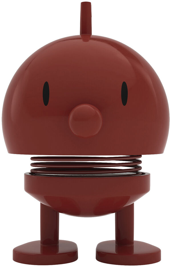 Auf weißem Hintergrund steht mittig eine weinrote Hoptimist-Figur "Bumble Maroon". Die kleine Figur mit runden Formen, schwarzen Augen und Stahlfeder verleiht eine fröhlich-verspielte Ausstrahlung. Sie besteht aus ABS und Stahl.