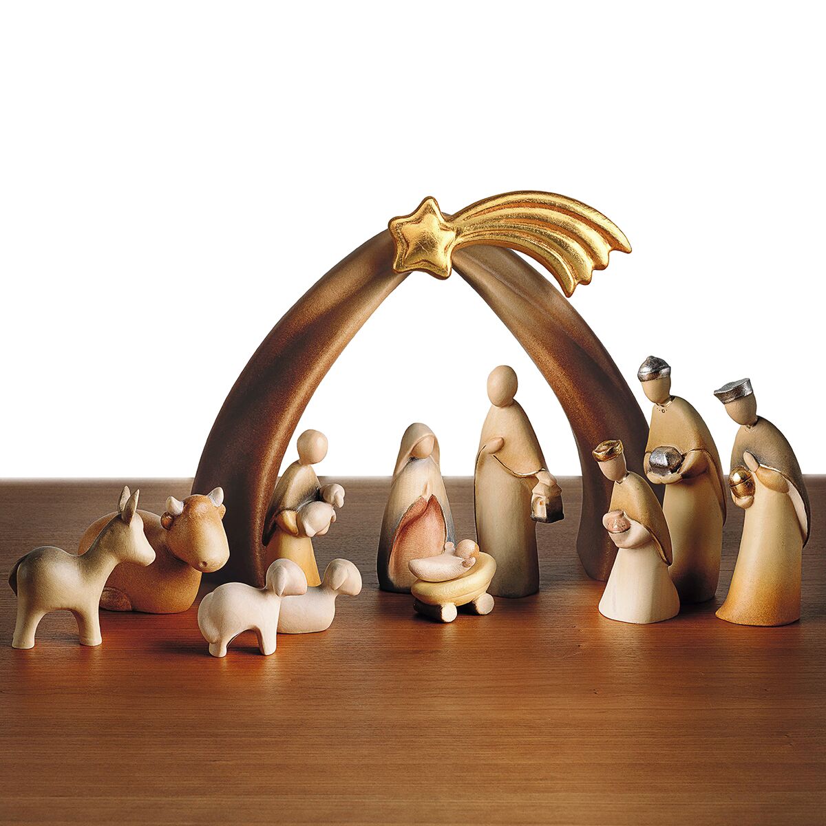 Zwölfteilige Weihnachtskrippe »Stern von Bethlehem« aus Holz mit goldener Sternschnuppe als Bogen, arrangiert auf einem Holztisch. Figuren stellen die Heilige Familie, die Drei Weisen, einen Engel sowie verschiedene Tiere dar. Dekorative Szene als traditionelle Weihnachtsdekoration.
