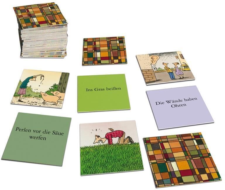 Das Bild zeigt das Memo-Legespiel 'Wände haben Ohren', bestehend aus mehreren Karten mit Illustrationen und Redewendungen. Einige Karten haben farbige Muster, andere zeigen Figuren in alltäglichen Szenen, und wieder andere haben Text wie 'Ins Gras beißen' und 'Die Wände haben Ohren'.