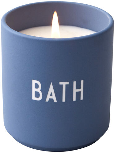 Eine Duftkerze in einem blauen Behälter mit der Aufschrift 'BATH'. Die Kerze ist entzündet und strahlt ein warmes Licht aus. Perfekt für Entspannung und Aromatherapie.