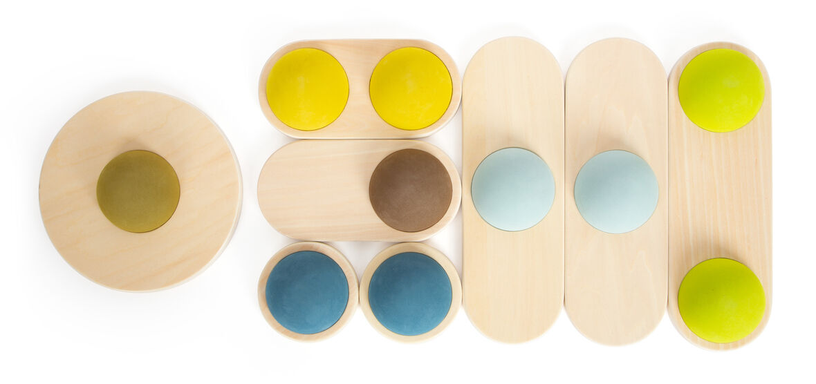 Foto von Balanciersteinen »Adventure«, ein aus Holz gefertigtes Balancespielzeug mit verschiedenen farbigen Steinen in Gelb, Braun, Blau und Grün sowie natürlichen Holzfarben.