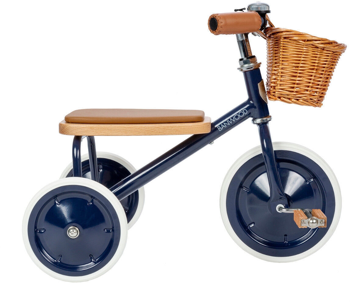 Ein Retro-Dreirad für Kinder mit einem blauen Metallrahmen, weißen Rädern und einem braunen Holzkorb am Lenker.