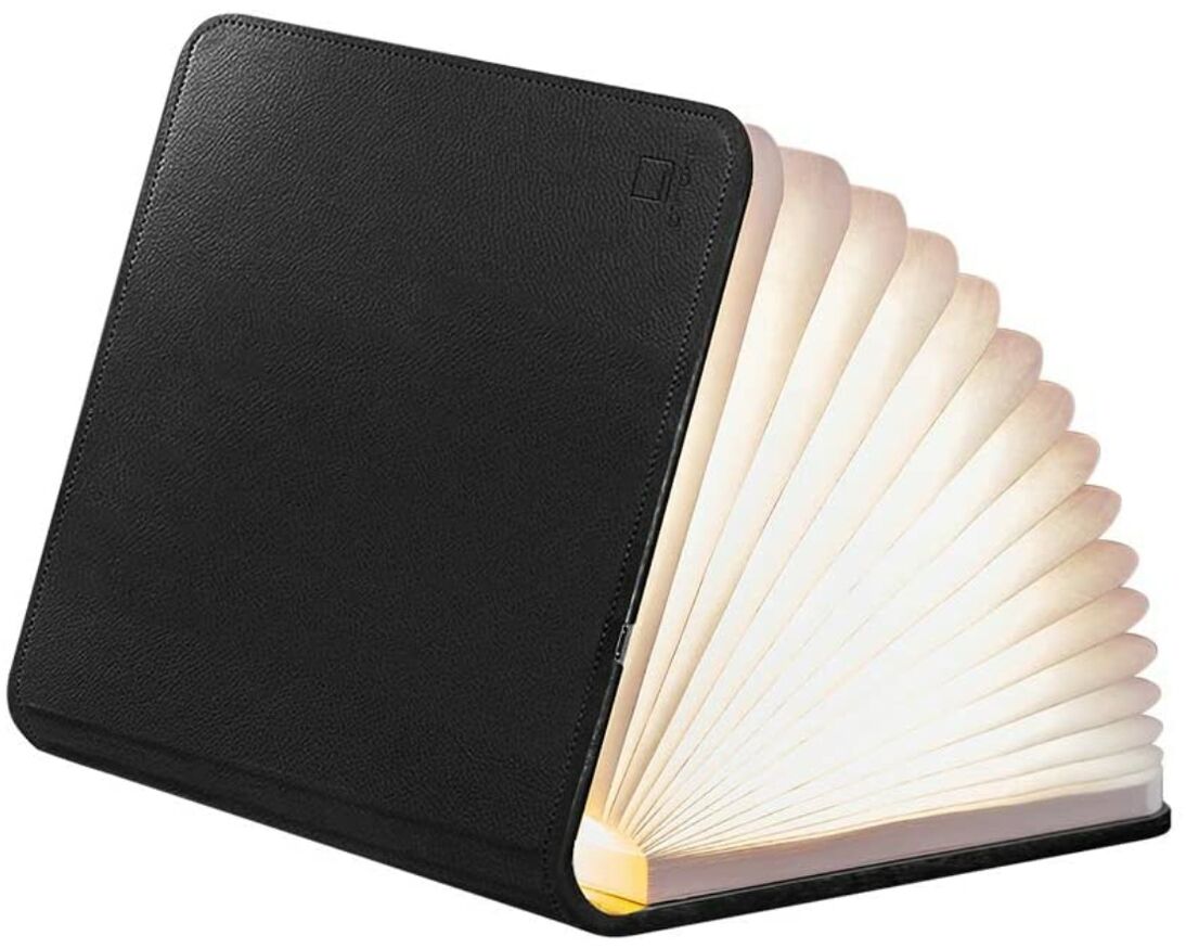 Die Smart Booklight in Leder schwarz ist eine klappbare Lampe, die durch ihr kreatives Buchdesign besticht. Die Außenseite besteht aus schwarzem Leder, während das Innere leuchtend weiße Falten hat, die an die Seiten eines Buches erinnern.