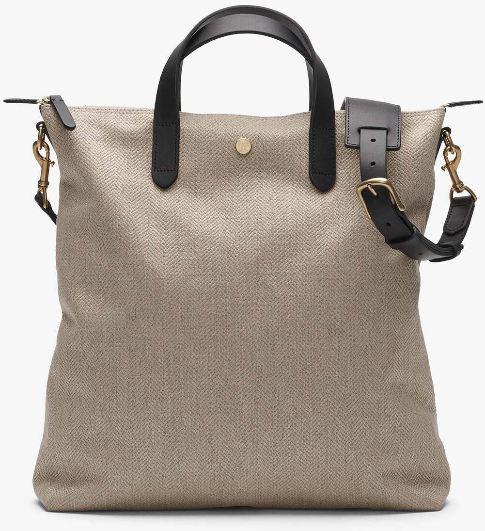 Eine beigen Shopper-Tasche von MISMO mit schwarzen Ledergriffen und goldenen Akzenten, ideal für stilvolle und hochwertige Nutzung.