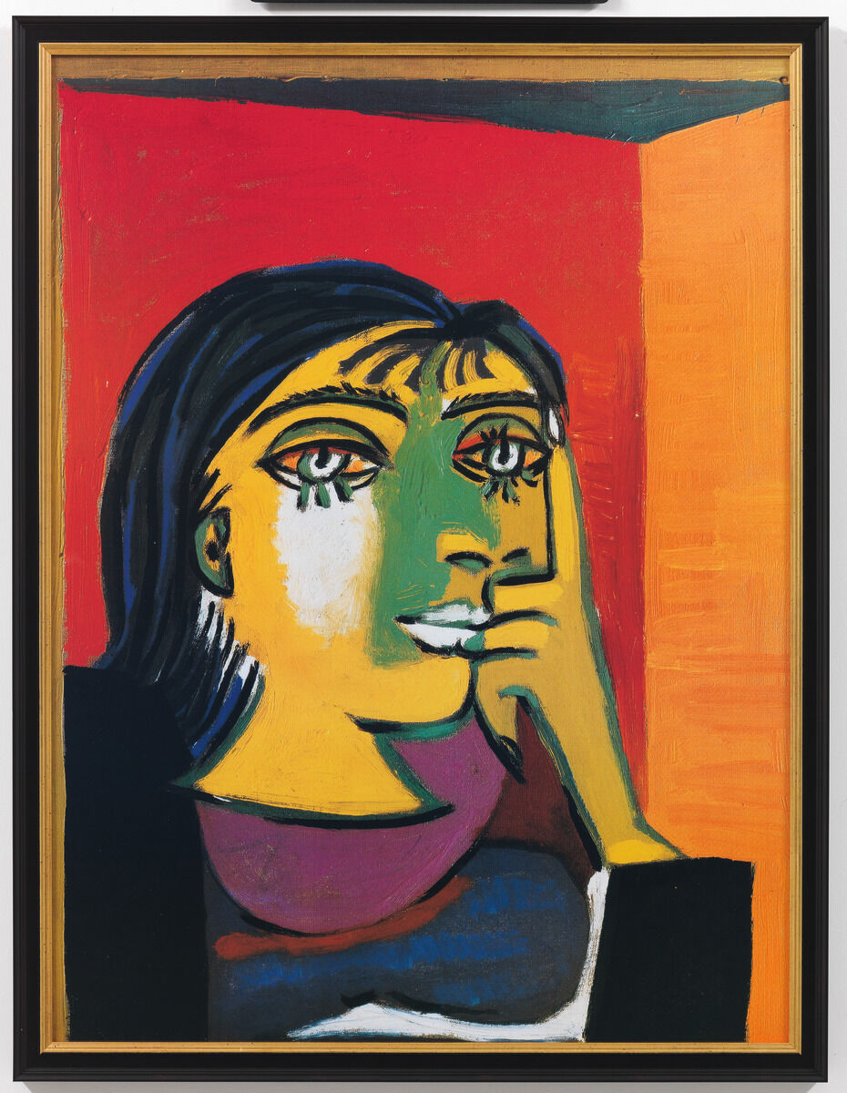 Ein Gemälde aus dem Jahr 1937 zeigt ein kubistisches Porträt von Dora Maar, gemalt von Pablo Picasso. Das Gesicht der Frau ist in Grüntönen gehalten, vor einem Hintergrund aus leuchtendem Rot und Orange. Weitere Farben wie Lila, Gelb, Weiß, Blau und Schwarz betonen die Details dieses expressionistischen Kunstwerks.