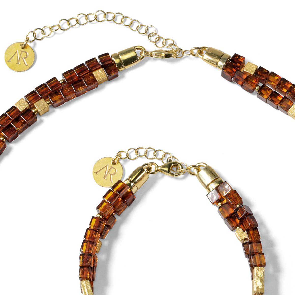 Das Bild zeigt ein edles Bernstein-Schmuckset namens »Annabele« der Marke Ars mundi. Es besteht aus einer Kette und einem Armband mit goldfarbenen Verschlüssen und Anhängern. Die Schmucksteine sind in warmen Bernsteintönen facettiert und an Metallösen befestigt.