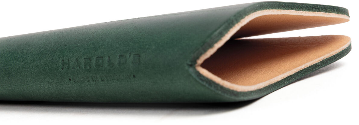 Das Bild zeigt ein hochwertiges, grünes Brillenetui aus festem Kernleder der Marke Harold's Lederwaren. Das Etui ist minimalistisch gestaltet, halb geöffnet und präsentiert außen grünes Leder sowie innen naturfarbenes Leder. Der Hintergrund ist weiß.