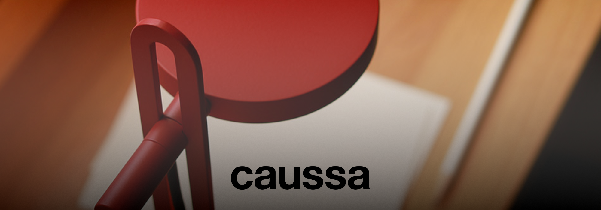 Rote Lampe mit einem runden Schirm und einem minimalistischen Design, darunter der Schriftzug 'caussa'.