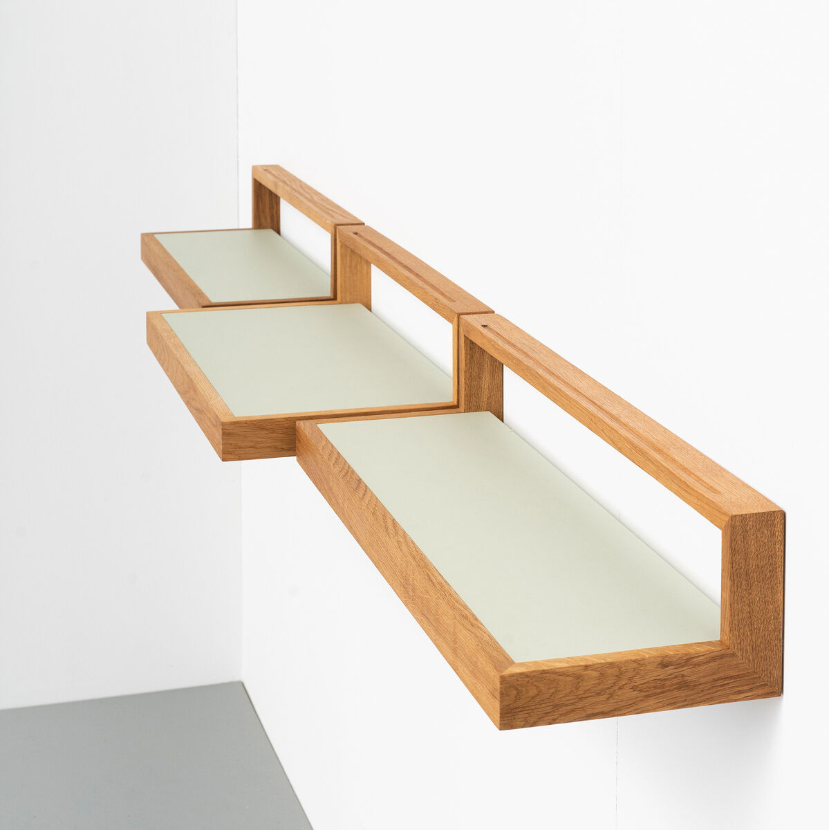 Ein modernes, wandmontiertes Ablagebord namens »buck« in der Farbe Pistazie. Das Regal besteht aus Naturholz und hat ein minimalistisches Design mit drei horizontalen Flächen. Geeignet für verschiedene Wohnräume, insbesondere für Liebhaber von modernem und funktionalem Design.