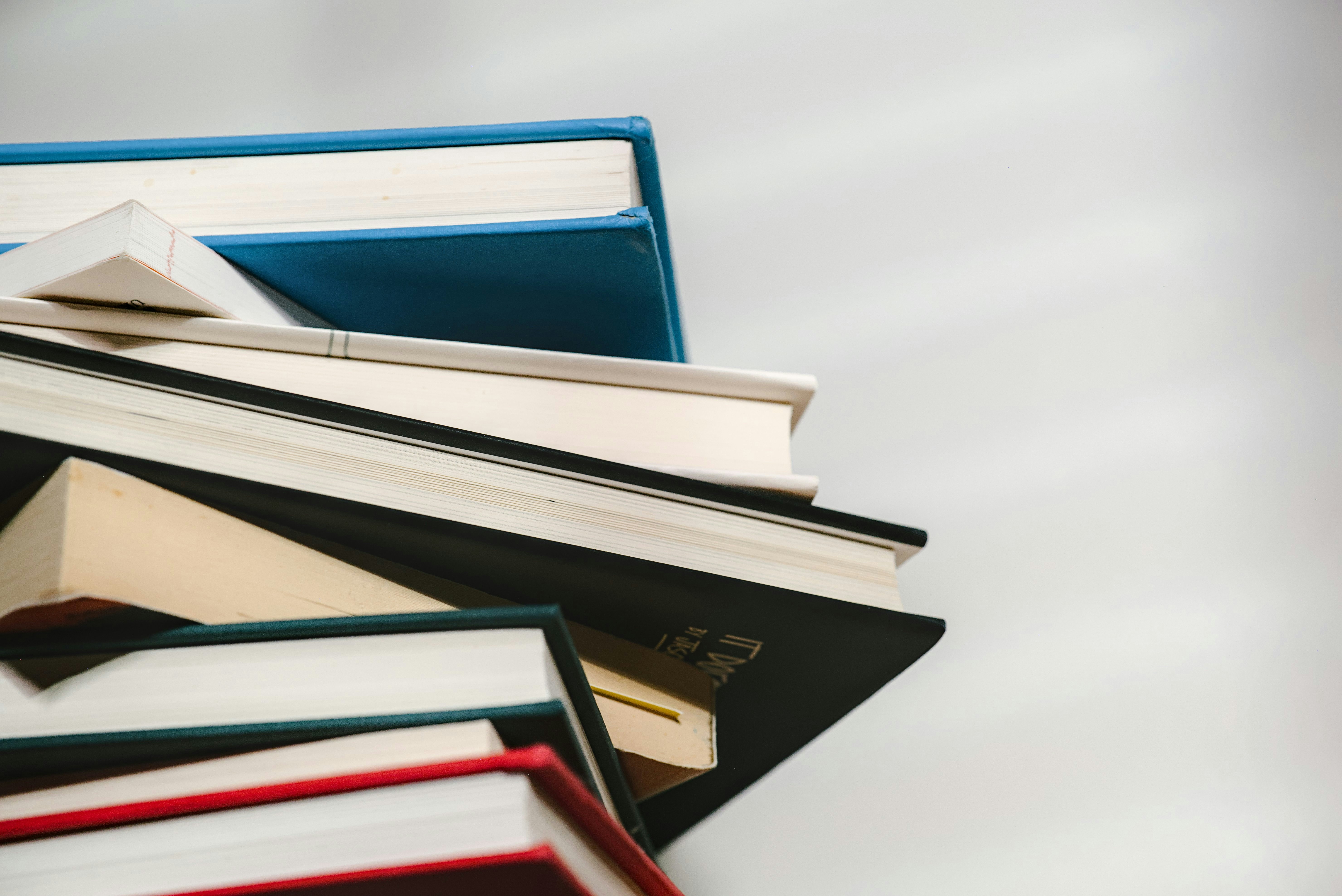 Mehrere Bücher liegen in einem Stapel aufeinander.