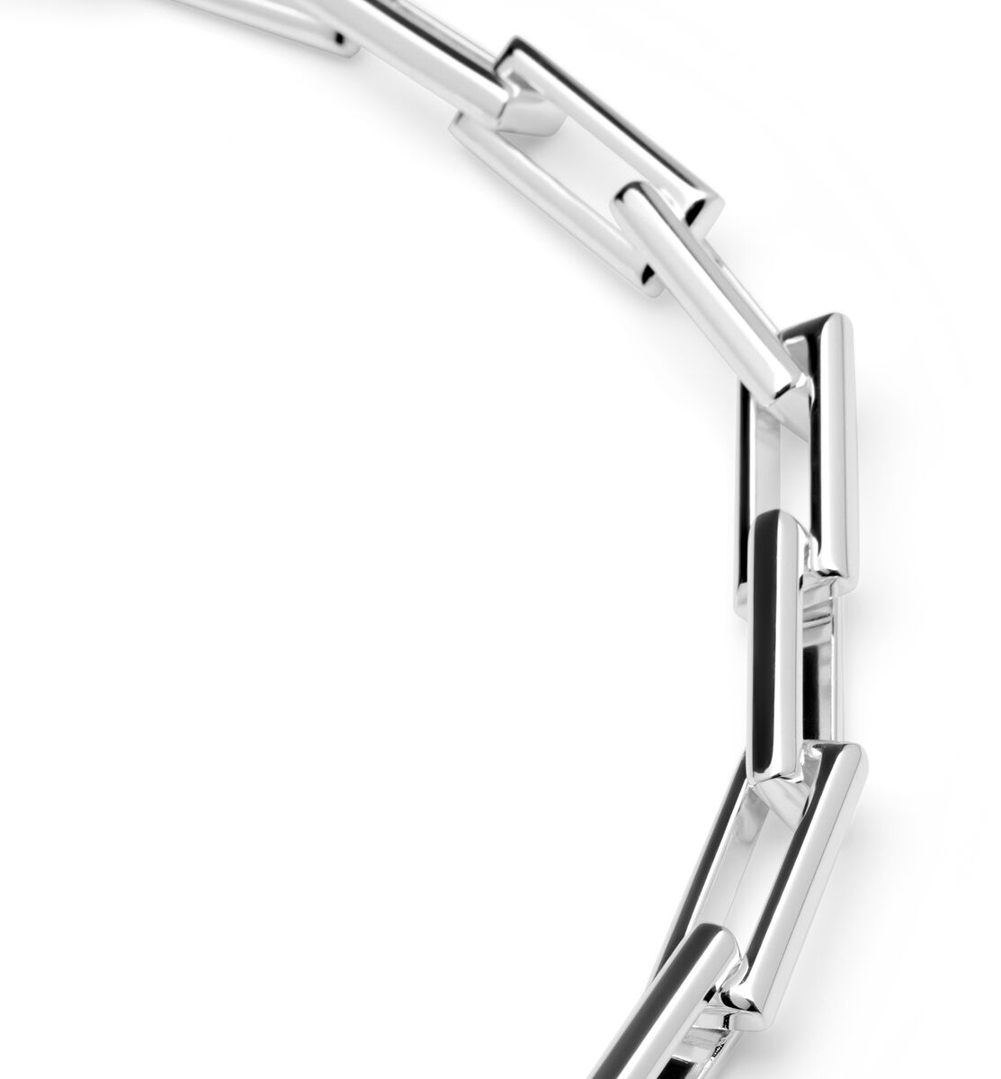 Detailaufnahme einer modernen Gliederhalskette aus poliertem Silber mit rechteckigen Elementen. Die Kette liegt auf weißem Hintergrund und zeigt ein elegantes, zeitgemäßes Design.