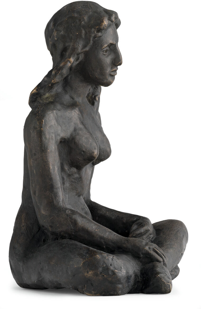 August Mackes Skulptur von 1912 zeigt eine sitzende nackte Frau, die aus bronzefarbenem Material gefertigt ist. Die Figur hat geschlossene Augen und scheint in einer meditativen Pose zu sein. Die Detaillierung betont die körperlichen Konturen und die Haarstruktur der Figur.