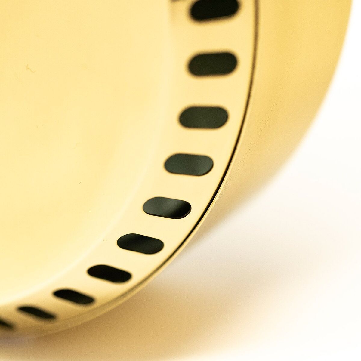 Nahaufnahme eines gelben, kreisförmigen Geräts mit schwarzen, ovalen Markierungen, bekannt als ZEIT-Sonderedition »POLAR Haar-Hygrometer«.