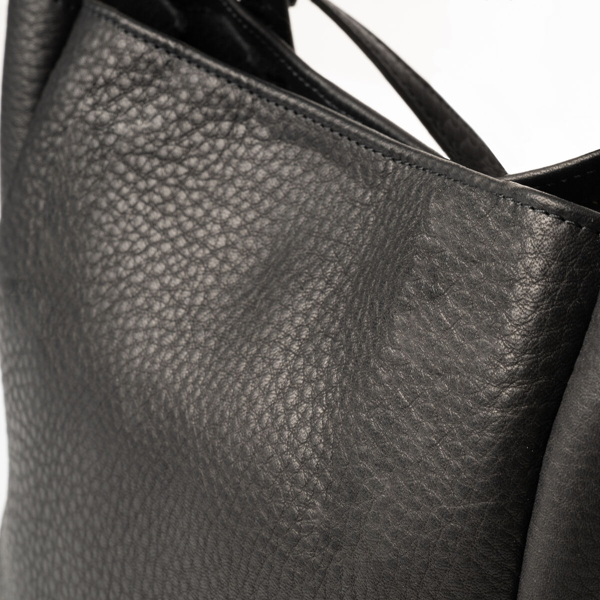 Eine hochwertige schwarze Ledertasche mit silbernen Verzierungen und dezenter Prägung, die strapazierfähiges und elegantes Leder zeigt.