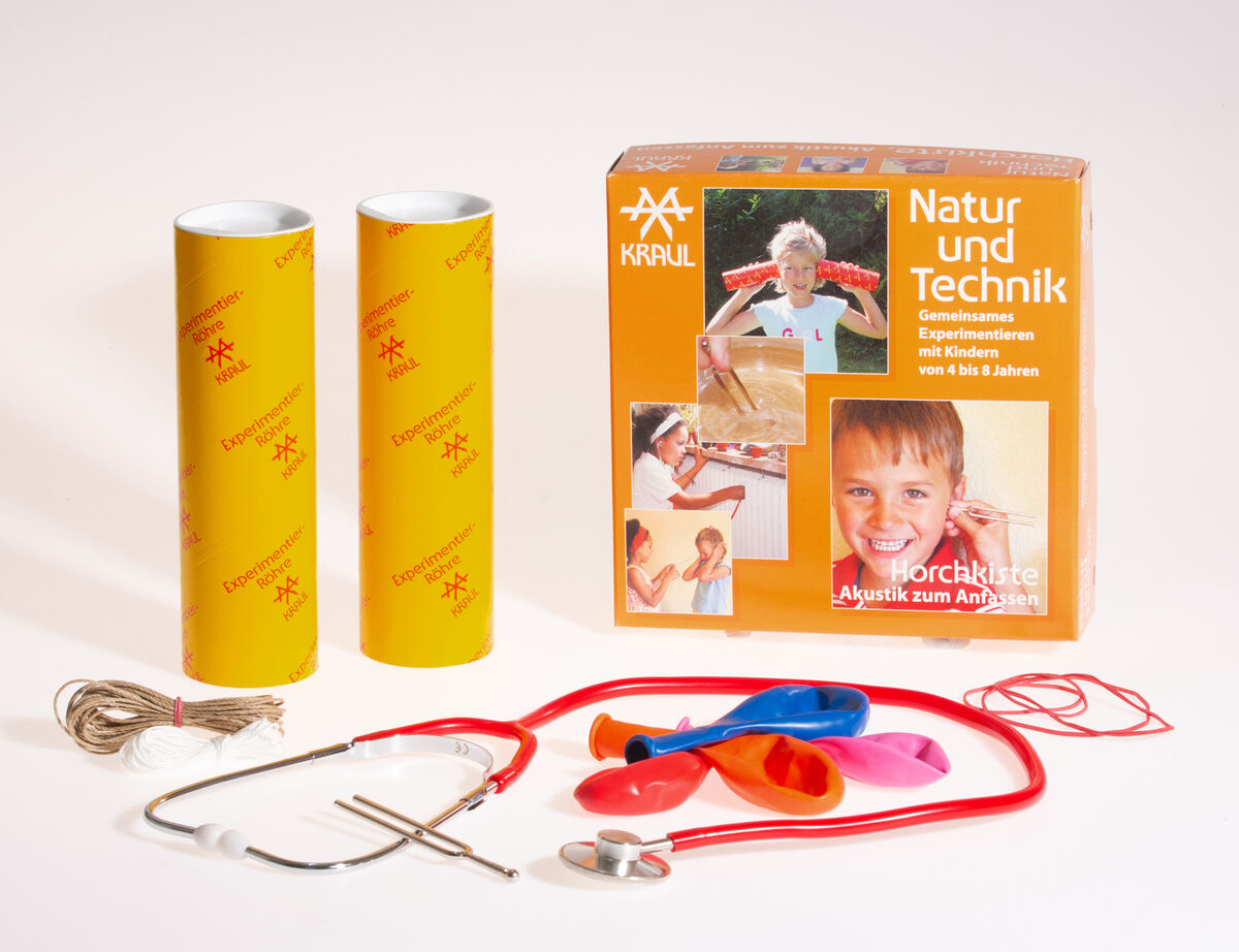 Ein Experimentierkasten namens »Horchkiste« von Kraul für Kinder von 4-8 Jahren. Enthält zwei gelbe Zylinder, ein Stethoskop, Ballons, Seil und eine orangefarbene Schachtel mit Informationen und Bildern.