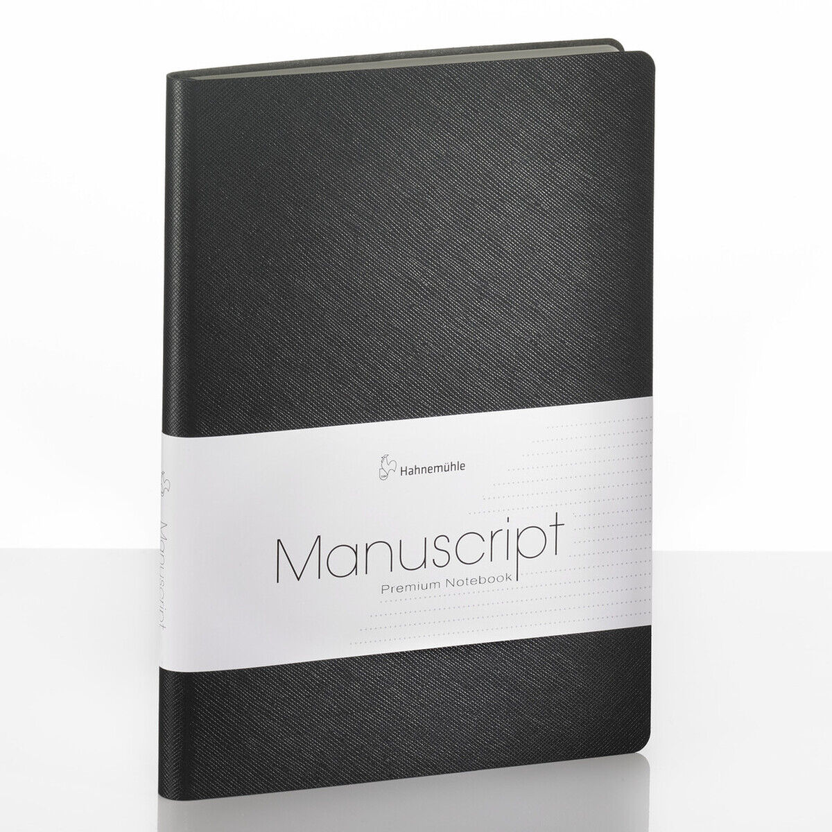 Ein schwarzes Notizbuch im DIN-A5-Format mit der Aufschrift »Manuscript«. Das Buch hat ein schlichtes, professionelles Design und befindet sich auf einer reflektierenden weißen Oberfläche.