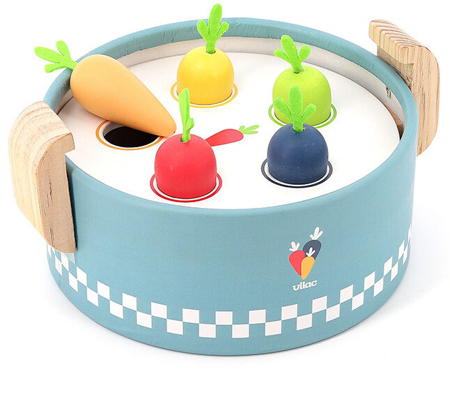Der Bunte Spielkochtopf ist ein pädagogisches Holzspielzeug für Kinder, das aus einem blauen Topf mit einem weißen Deckel besteht. Darauf befinden sich verschiedene bunte Gemüsefiguren (Karotte, Tomate, Zwiebel, Rübe) mit grünen Blättern. Der Topf hat zwei Griffe aus Holz und eine kleine Karotte ist als Logo auf der Seite des Topfes zu sehen.