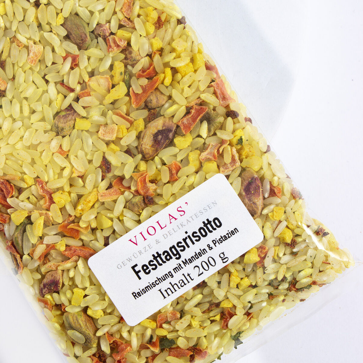 Eine Packung mit herzhaftem Weihnachtshaus-Risotto von Violas, eine Reismischung mit getrocknetem Gemüse und Gewürzen, verpackt in einem durchsichtigen Beutel mit einem weißen Etikett.