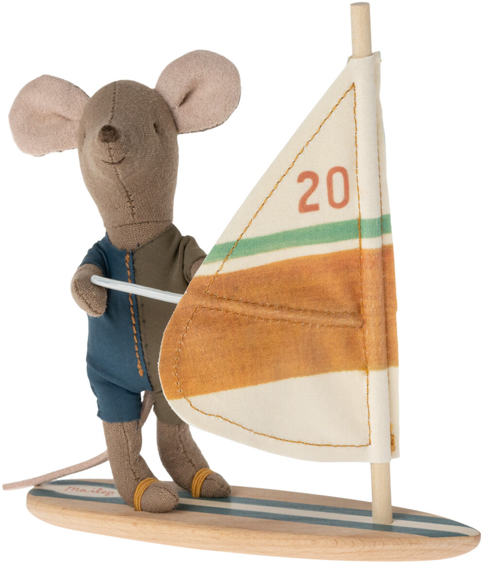 Eine Stoffmaus in einem blauen Anzug steht auf einem Surfbrett mit einem Segel. Das Brett hat Streifen in Orange und Grün. Die Maus hält das Segel mit beiden Händen.
