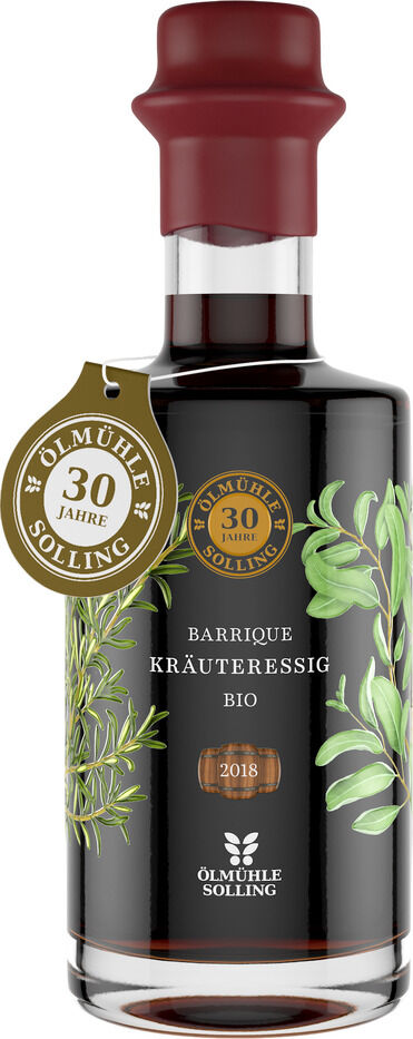 Eine edle Glasflasche Kräuteressig Barrique von Ölmühle Solling mit Jubiläumsanhänger "30 Jahre", verziert mit grünen Blättern auf schwarzem Etikett. Der Flaschenhals ist mit rotem Wachs versiegelt, goldene und weiße Schrift unterstreichen das hochwertige Bio-Produkt.