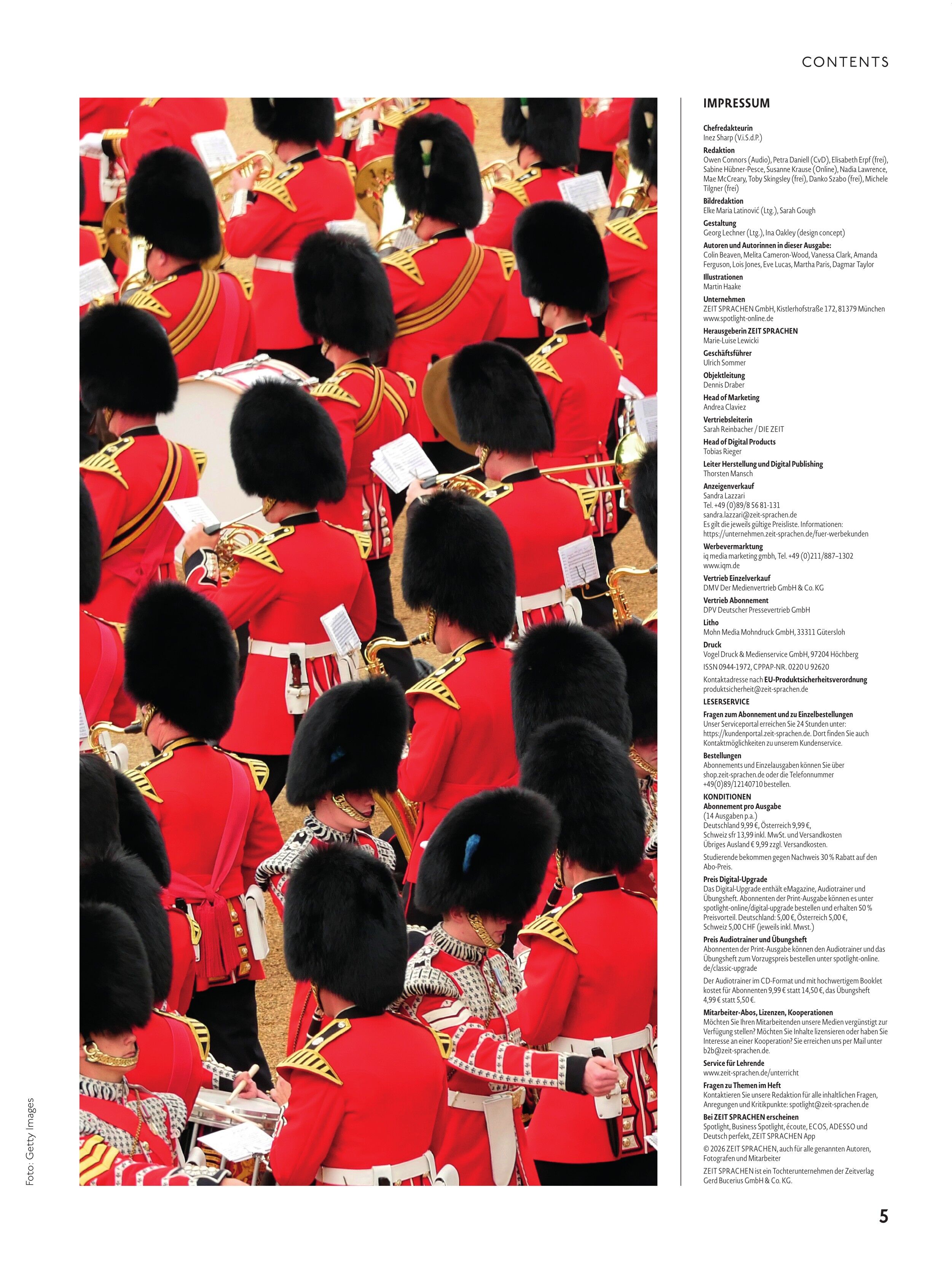 Detailreiche Aufnahme mehrerer britischer Gardesoldaten in roten Uniformen mit Goldverzierung und schwarzen Bärenfellmützen, die sich dicht gedrängt in Formation aufstellen; einige halten Musikinstrumente. Der Hintergrund zeigt hellbraunen Boden. Rechts daneben ein weißer Textbereich mit Impressum und Inhaltsverzeichnis.