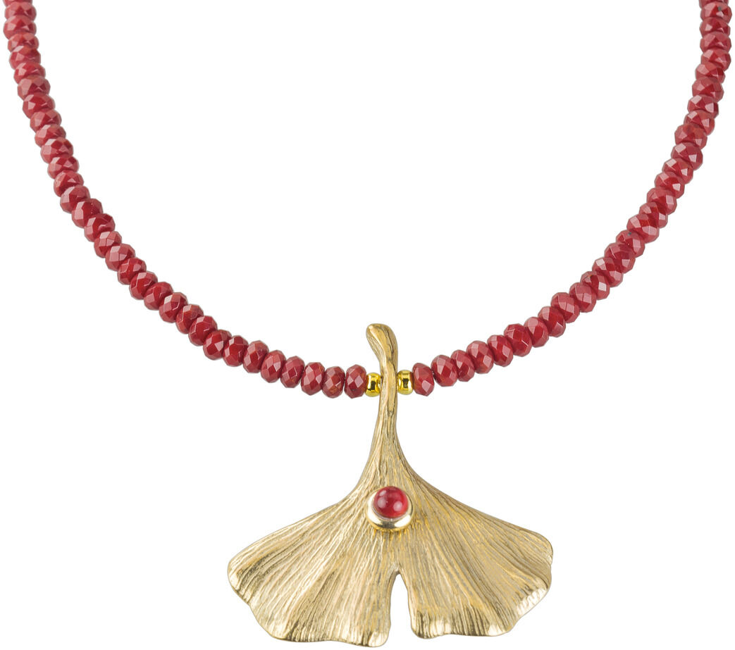 Ein handgefertigtes Collier von Petra Waszak mit dem Motiv eines Ginkgo-Blattes, verziert mit einem roten Achatstein. Die Kette besteht aus roten Perlen und einem goldfarbenen Anhänger in Form eines Ginkgo-Blattes.