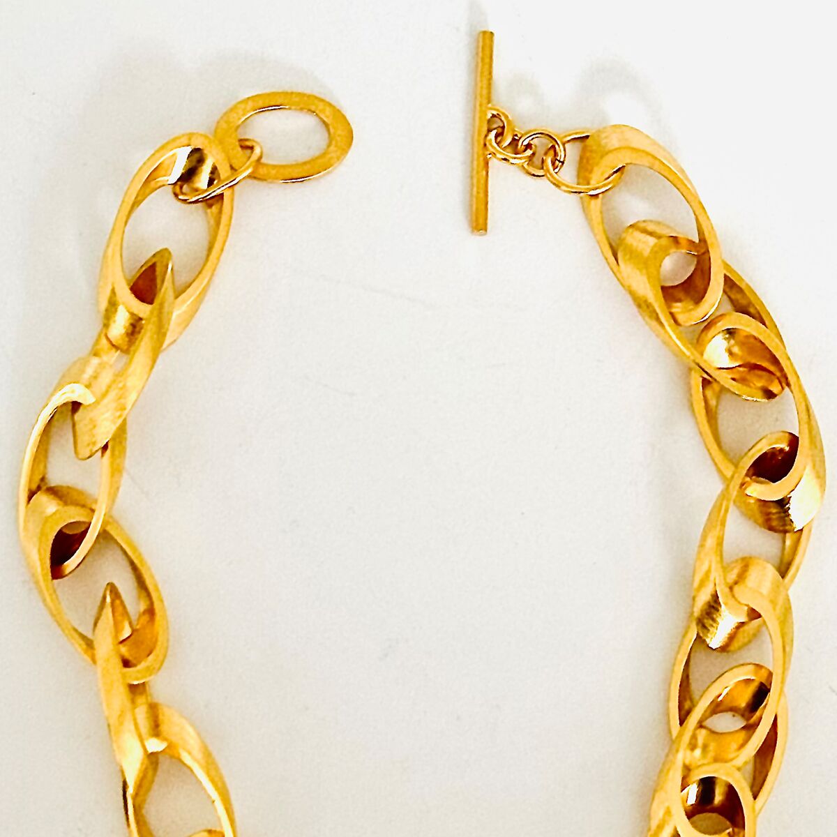 Bild einer massiven Gliederkette als Collier, deren Kettenglieder feingoldplattiert und aus 925er Silber gefertigt sind. Die Kette zeigt ein glänzendes Oberflächenfinish und einen Knebelverschluss. Das Collier wirkt luxuriös, elegant und ist auf einem hellen Hintergrund platziert.