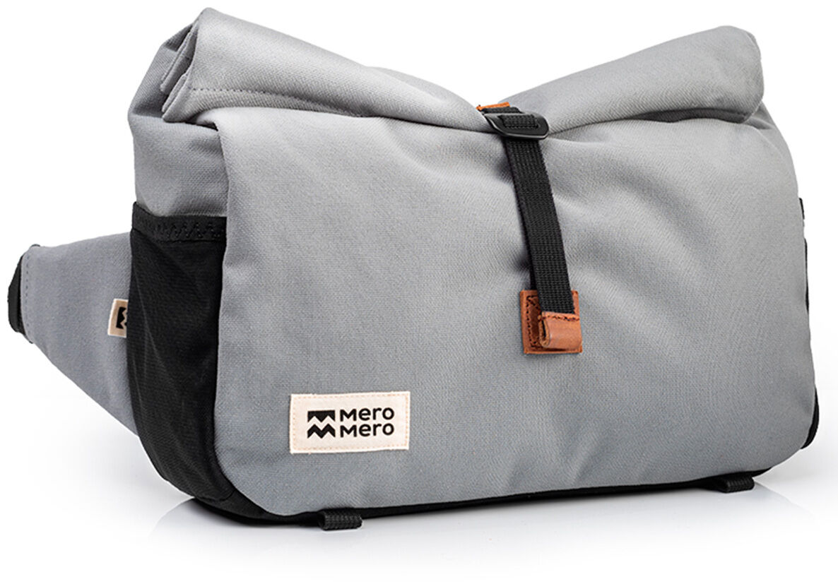 Graue Tasche mit schwarzem und braunem Detail, beschriftet mit 'Mero Mero'. Geeignet für Outdoor- und Urbanen Aktivitäten.