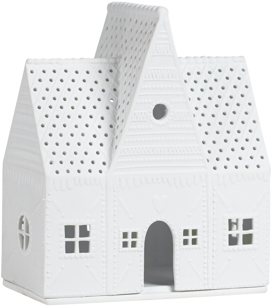 Ein weißes, dekoratives Lichthaus in Form eines Lebkuchenhauses aus Keramik mit durchbrochenem Muster und Details auf dem Dach und den Wänden. Es verfügt über kleine Fenster und eine Türöffnung.