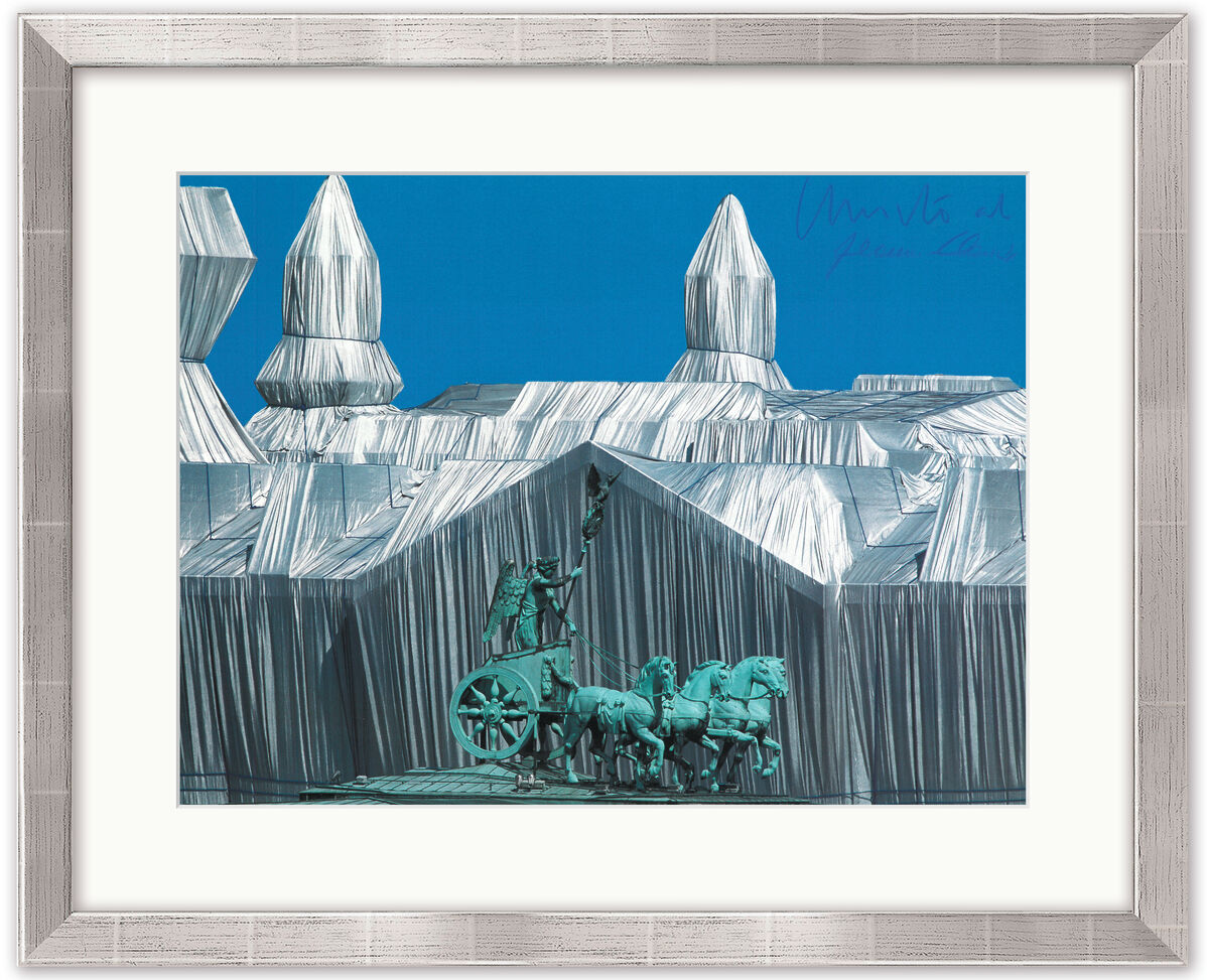 Rahmenbild zeigt das berühmte verpackte Reichstagsgebäude mit der Quadriga in Berlin, gestaltet von Christo und Jeanne-Claude. Die monumentale Kunstinstallation ist mit silbernen Stoffbahnen bedeckt, während Himmel und Quadriga in intensiven Blau- und Grüntönen gehalten sind.