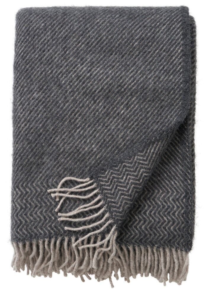 Graue und beige Decke mit Fransen im modernen Design, ideal als Wohnaccessoire für ein gemütliches Ambiente.