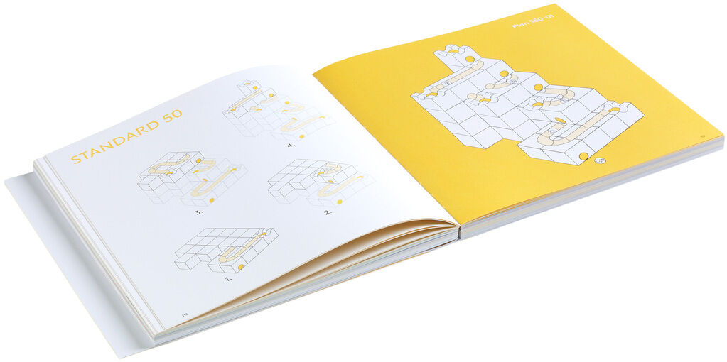 Das Bild zeigt ein aufgeschlagenes Buch zur Kugelbahn »CUBORO - DAS BUCH« mit gelben und weißen Seiten. Es sind Bauanleitungen für verschiedene Kugelbahnmodelle abgebildet.