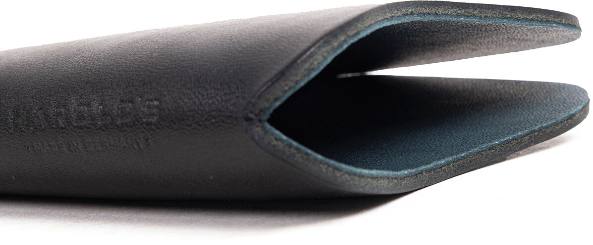 Das Bild zeigt ein elegantes Kernleder Brillenetui in Schwarz. Das Etui hat eine schlanke, moderne Form mit einer offenen Seite zum Einschieben einer Brille. Die Außenseite ist matt schwarz, die Kanten und die Innenseite wirken dunkelgrün bis grau.